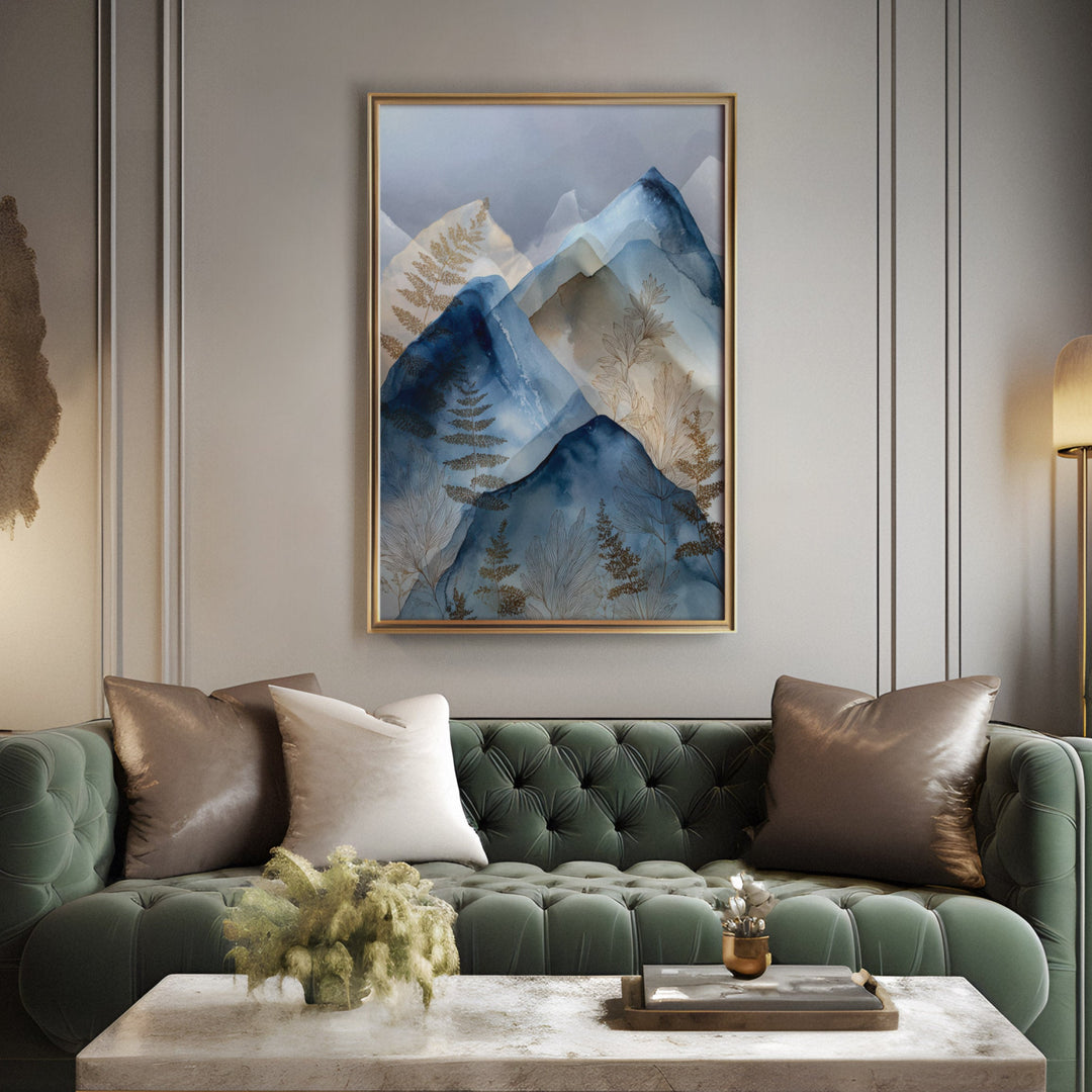 Watercolor layered blue mountain peaks with gold botanical fern details on a misty, displayed above a sofa in a living room
